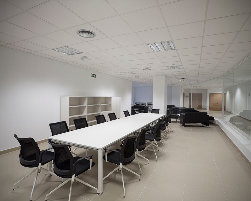 Vista del interior de la sala de reuniones del CETIC donde se ve una gran mesa rodeada de sillas y sofás al fondo