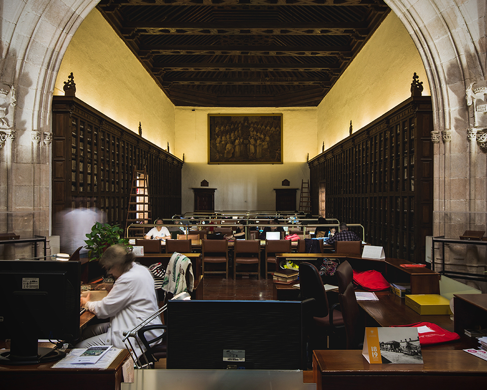 Sala de estudio de la biblioteca del Hospital Real con estudiantes y personal de la biblioteca